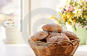 Homemade fresh round buns with a crispy brown crust in a wicker basket