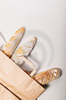 Homemade fresh sourdough bread. Mouth-watering baguettes. Homebaked bread in a paper bag. Eco-friendly style concept. Flat lay.