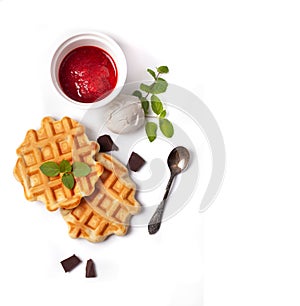 Homemade freshly baked belgian waffles with mascarpone, mint leaves and strawberry sauce isolated on white background