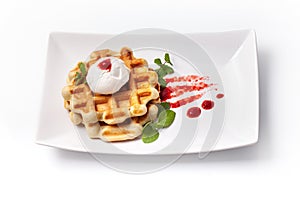 Homemade freshly baked belgian waffles with mascarpone, mint leaves and strawberry sauce isolated on white background