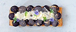 Dessert Saint Onore. Berry pie. Puff pastry tart with profiteroles, butter cream, black currant jam with fresh mint, lavender photo