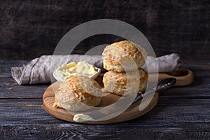 Homemade freshly baked scones with cheese and herbs on wooden board on wooden table