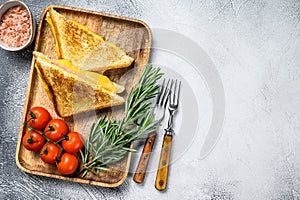 Homemade fried ham and cheese sandwich on a cutting board. White background. Top view. Copy space