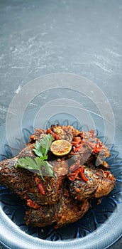 Homemade fried parrot fish with chilli is asian culinary food, served on a stone pad