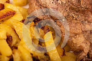 Homemade fried potatoes and a large piece of meat on a white plate