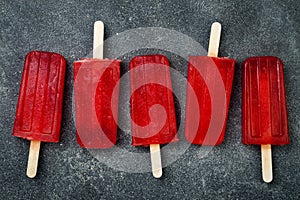 Homemade frozen blood orange natural juice alcoholic popsicles - paletas - ice pops. Overhead, flat lay, top view.