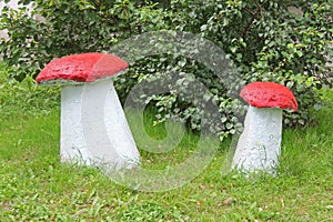 Homemade garden sculptures large mushrooms on the lawn. Landscaping yard and garden.