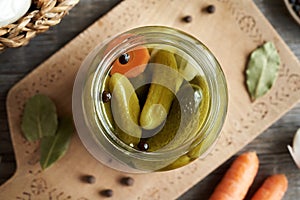 Homemade gherkins or pickled cucumber in a glass jar, top view