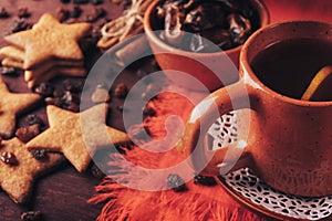 Homemade ginger cookies, cup of tea with lemon, dates, cinnamon with raisins