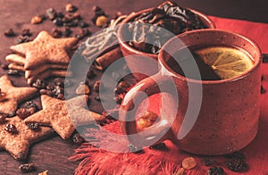 Homemade ginger cookies, cup of tea with lemon, dates, cinnamon with raisins