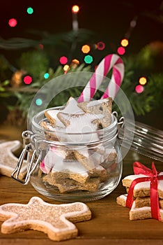 Homemade Gingerbread Biscuits in Glass Jar Christmas Background Holiday Festive Greeting Card Candy Cane Lights Wooden Background