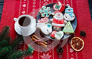 Homemade gingerbreads on plate and cup of coffee on red background. Holidays and celebration concept, greeting card