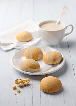 Homemade gluten free cottage cheese rice cookies and cup of tea with milk on light backgroun