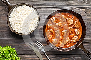 Homemade goulash traditional European beef meat stew soup spicy gravy food in cast iron pan with rice