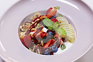 Homemade granola bowl with yogurt, banana and fresh assorted berries. healthy breakfast concept