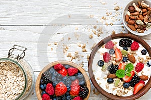 Homemade granola with greek yogurt, nuts and fresh berries in a bowl with cereal in ja