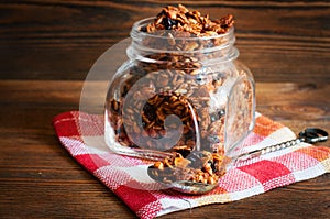 Homemade granola in open glass jar. Selective focus