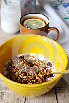 Homemade granola with yogurt and tea with lemon. Useful breakfast. Rustic style, selective focus.