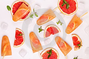Homemade grapefruit popsicle with ripe grapefruit slices and fresh mint