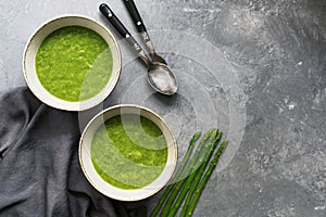 Homemade green cream of asparagus soup on a gray background. Top view,copy space