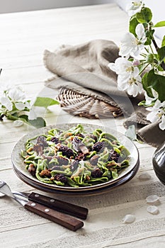 Homemade green nettle pasta with fried spring morel mushrooms