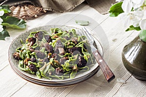 Homemade green nettle pasta with fried spring morel mushrooms