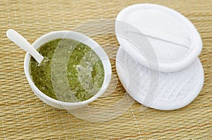 Homemade green tea (matcha, kelp, algae, spirulina) face or hair mask (scrub) and wooden hairbrush.