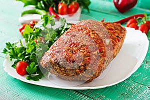 Homemade ground beef meatloaf with ketchup and bell peppers.