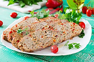 Homemade ground beef meatloaf with ketchup and bell peppers.