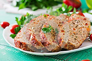 Homemade ground beef meatloaf with ketchup and bell peppers.