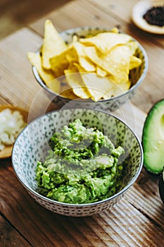 Homemade guacamole with corn chips tortillas - Traditional spicy Mexican preparation