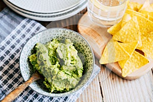 Homemade guacamole with corn chips tortillas - Traditional spicy Mexican preparation