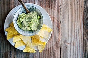 Homemade guacamole with corn chips tortillas - Traditional spicy Mexican preparation