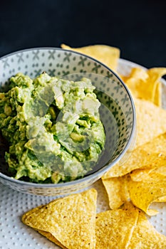 Homemade guacamole with corn chips tortillas - Traditional spicy Mexican preparation