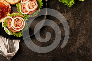 Homemade hamburger ingredients. Black board background. Space for text