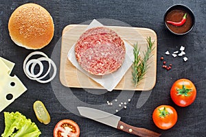 Homemade hamburger ingredients on a black table
