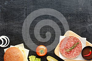 Homemade hamburger ingredients on a black table
