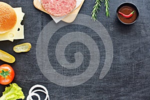 Homemade hamburger ingredients on a black table