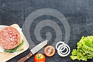 Homemade hamburger ingredients on a black table