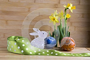 Homemade handmade czech painted eggs and wooden bunny, yellow narcissus pseudonarcissus in bloom