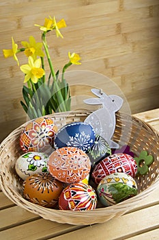 Homemade handmade czech painted eggs and wooden bunny, yellow narcissus pseudonarcissus in bloom