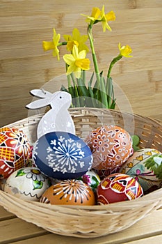 Homemade handmade czech painted eggs and wooden bunny, yellow narcissus pseudonarcissus in bloom