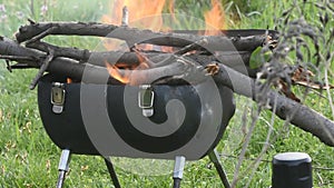 homemade handmade grill from a cylinder with burning firewood against a background of nature