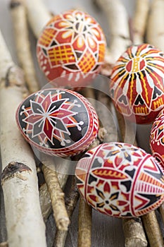 Homemade handmade painted Easter eggs on birch branches on grey wooden tray, traditional hnadcraft eggs