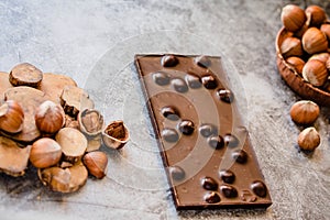 Homemade hazelnut chocolate bar. Nuts and chocolate background. Ingredients for cooking homemade chocolate sweets. Confectionery