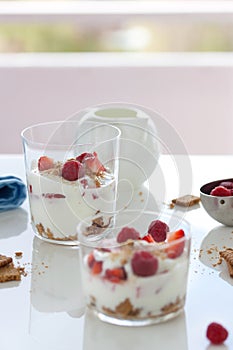 Homemade healthy dessert in a glass with yogurt, fresh fruits and cookies for breakfast