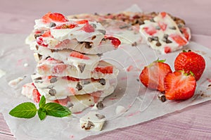 Homemade healthy frozen strawberry yogurt bark on rustic wooden