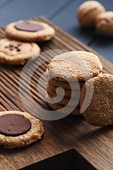 Homemade healthy gluten free sugar free vegetarian sweets. Peanut butter cookies with dark chocolate drops on dark oak board