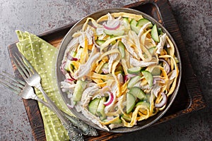 Homemade healthy salad of boiled chicken, sliced omelette, cucumber and onion close-up in a plate. horizontal top view