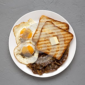 Homemade Healthy Sunnyside Eggs Breakfast on a white plate on a gray background, overhead view. Flat lay, top view, from above